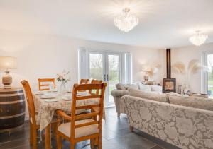 uma sala de estar com uma mesa e um sofá em Cluniac Cottage em Menai Bridge