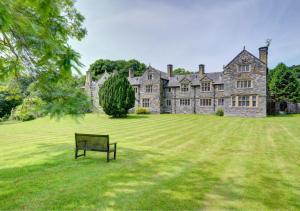 un banco de parque frente a un gran castillo en The Manor Criccieth, en Porthmadog