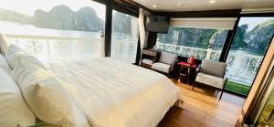 a bedroom with a white bed and a large window at UniCharm Cruise in Ha Long