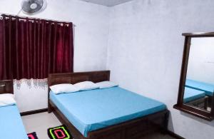 a small room with two beds and a mirror at Serene Homestay in Anuradhapura