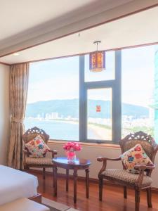 a room with two chairs and a table in front of a window at Huong Viet Hotel Quy Nhon - Beachfront in Quy Nhon