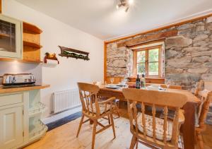 LlanfachrethにあるMaesgwm Farm Cottageのキッチン(木製テーブル、椅子付)