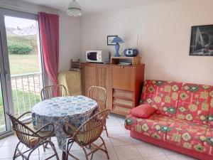 een woonkamer met een tafel en een bank bij Appartement Jullouville, 1 pièce, 2 personnes - FR-1-361-10 in Jullouville-les-Pins