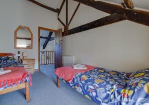1 dormitorio con 2 camas y espejo en Cwm Hesgen, en Rhydymain