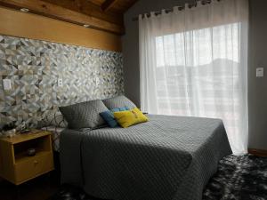 a bedroom with a bed with two pillows and a window at Moradas Desterro, próximo ao aeroporto 22 in Florianópolis