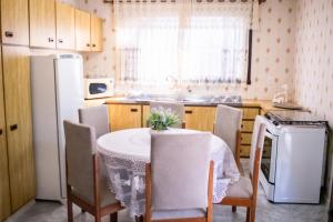 a kitchen with a table and chairs and a refrigerator at Casa Di Mattoni in Bento Gonçalves