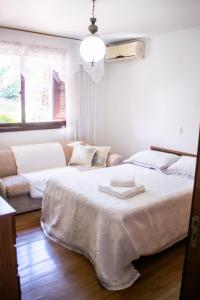 a bedroom with two beds and a couch at Casa Di Mattoni in Bento Gonçalves