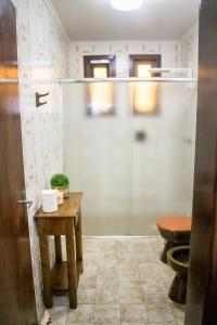 uma casa de banho com um chuveiro, um WC e uma mesa em Casa Di Mattoni em Bento Gonçalves