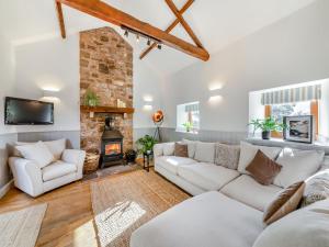 a living room with a couch and a fireplace at Barn On The Wall in Walton