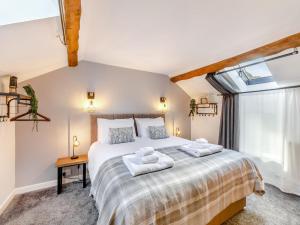 a bedroom with a large bed with towels on it at Barn On The Wall in Walton
