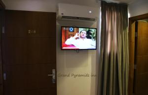 a television in a bathroom with a man on it at Grand Pyramids Inn in Cairo
