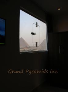 a room with a window with a view of the pyramids at Grand Pyramids Inn in Cairo