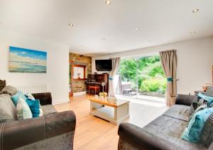 a living room with two couches and a table at The Lodge in Pwllheli