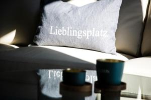 a couch with a pillow with two cups on it at Ferienhaus "Q" - Wohnung 3 in Zingst