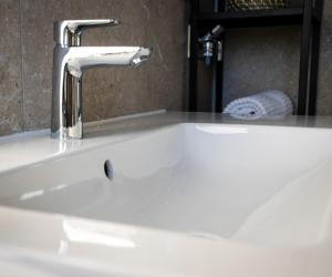 a white sink with a faucet in a bathroom at Ferienhaus "Q" - Wohnung 3 in Zingst +9 photos