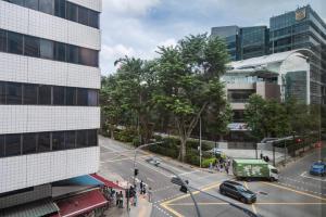 een drukke straat met auto's en een bus bij Tai Hoe Hotel in Singapore