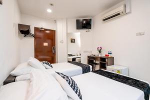 een hotelkamer met 2 bedden en een bureau bij Tai Hoe Hotel in Singapore