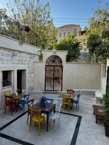a patio with tables and chairs and a stone wall at Reeja art gallery in Nazareth