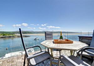 ポルスマドグにあるThe Boathouseのテーブルと椅子、水辺の景色を望むバルコニー