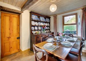 comedor con mesa de madera y ventana en Tyn Gaer en Llanfachreth