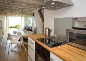 a kitchen with a stove top oven next to a table at Glanaber Bach in Abersoch