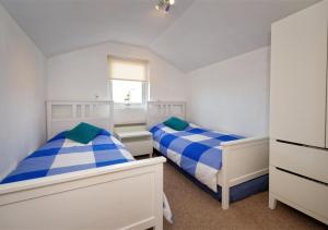 a bedroom with two beds and a window at Glanaber Bach in Abersoch