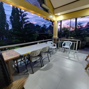 une terrasse avec une table blanche et des chaises. dans l'établissement Modern House Staycation in Bacolod, à Bacolod