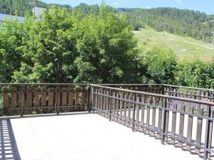 une passerelle en bois avec une clôture en bois et des arbres dans l'établissement Studio Pra-Loup, 1 pièce, 5 personnes - FR-1-691-16, à Pra-Loup