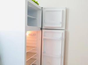a white refrigerator with its door open with its door open at JJ House Gwangan Beach 드론쇼 매주토요일8시10시 in Busan