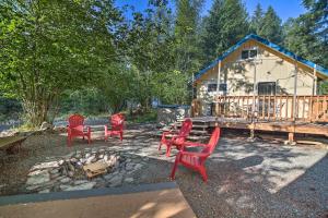 a group of red chairs in front of a cabin at Wandering Elk Cabin Retreat with Golf Access! in Packwood