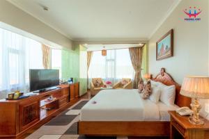 Huong Viet Hotel Quy Nhon - Beachfront في كوي نون: غرفة نوم بسرير وتلفزيون بشاشة مسطحة