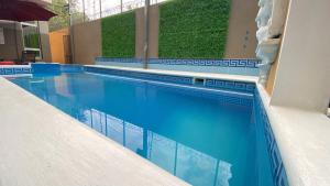 una piscina con acqua blu in un edificio di Real Guanacaste a San Pedro Sula
