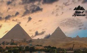 a painting of the pyramids of giza under a cloudy sky at Grand Pyramids Inn in Cairo