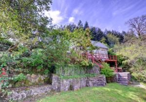 a garden with a stone wall and a house at Ty Dulas in Esgair-geiliog