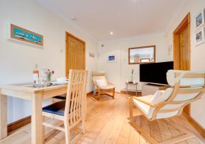 a living room with a table and chairs and a television at Hallstatt in Saundersfoot