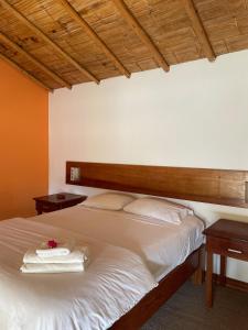 um quarto com uma cama com duas mesas de cabeceira e duas mesas em La Casa de Pitty em Máncora