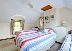 a bedroom with two beds and a window at Llysyfelin in Pontfaen