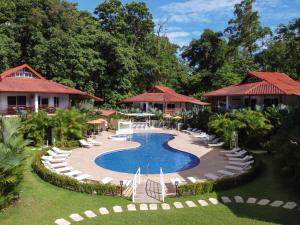um resort com piscina, cadeiras e árvores em Terrazas del Caribe Aparthotel em Puerto Viejo
