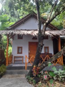 a small house with a thatched roof at anik homestay & dormy Batukaras in Batukaras