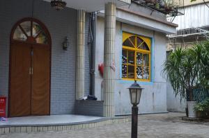 a building with a brown door and a street light at No. 6 Cuobian Hostel in Shantou