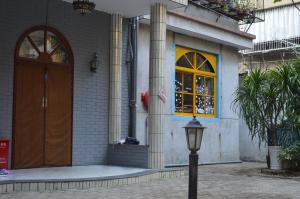 un bâtiment avec une porte marron et un éclairage de rue dans l'établissement No. 6 Cuobian Hostel, à Shantou