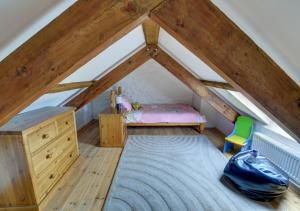 a room with a bed and a desk in a attic at Holly Cottage in Haverfordwest