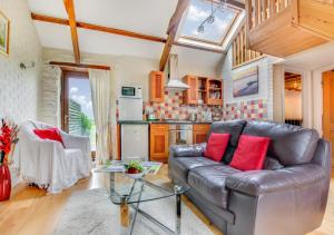 a living room with a leather couch and a table at Primrose Cottage in Haverfordwest
