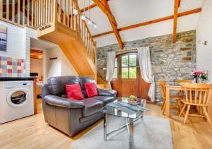 a living room with a leather couch and a table at Primrose Cottage in Haverfordwest