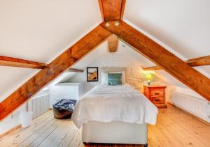a bedroom with a white bed in a attic at Primrose Cottage in Haverfordwest