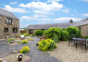 a garden with a patio and a table and chairs at Primrose Cottage in Haverfordwest
