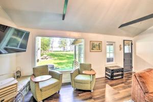a living room with chairs and a table and a large window at Crivitz Lakefront Escape with Boat Dock and Slip! in Crivitz