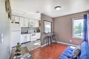 a living room with a blue couch and a kitchen at Louisville Apartment - Walk to Restaurants! in Louisville