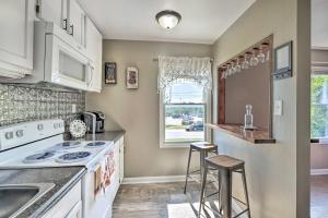a kitchen with white appliances and a counter with stools at Louisville Apartment - Walk to Restaurants! in Louisville