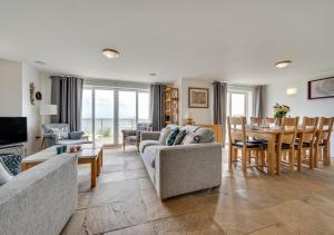 a living room with a couch and a dining room at Sunridge in Amroth